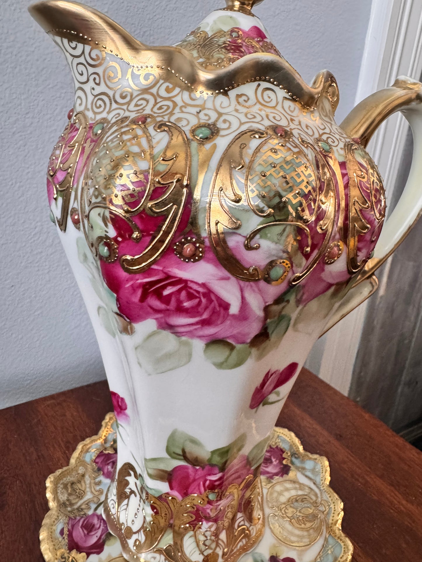 Hand-painted Nippon porcelain chocolate pot and saucer with raised gold detailing.