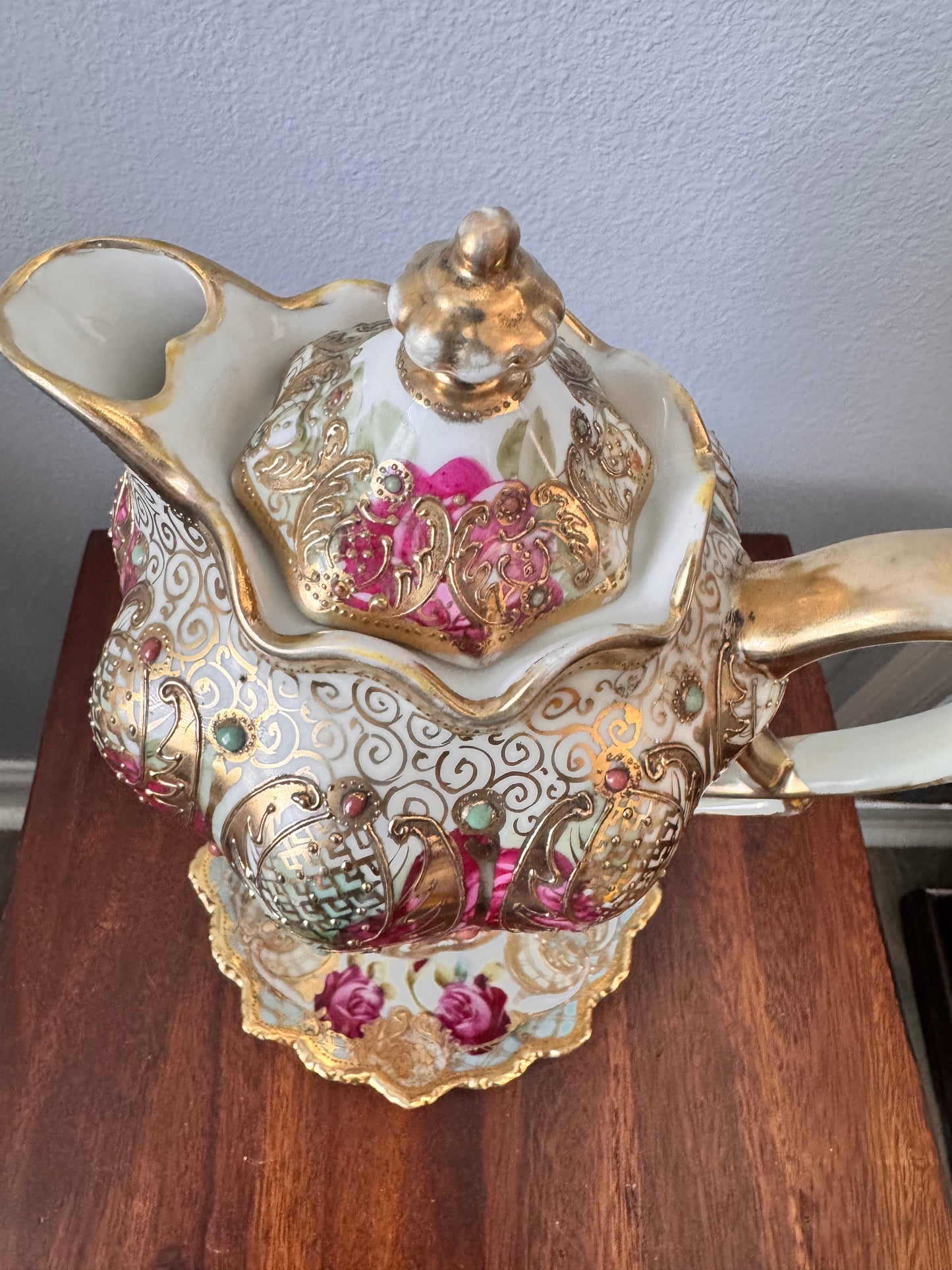 Hand-painted Nippon porcelain chocolate pot and saucer with raised gold detailing.